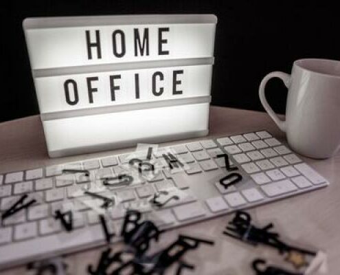 A sign behind a keyboard that reads "Home Office"